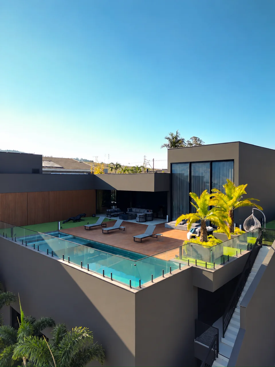 Vista elevada da residência com piscina e deck de madeira