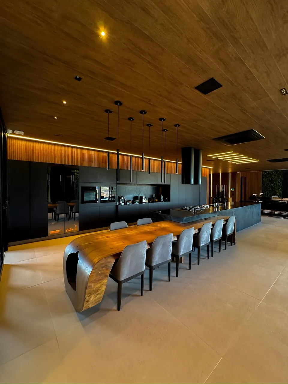 Cozinha integrada com ilha e mesa de madeira