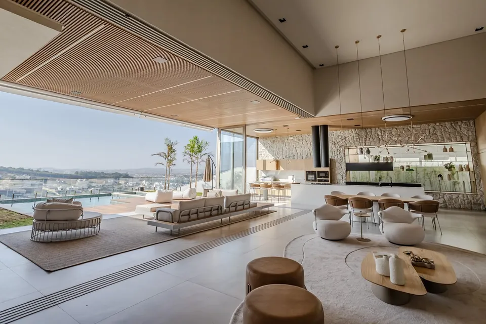 Sala integrada à varanda, com piscina ao fundo