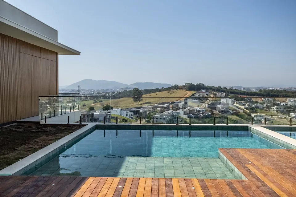 Piscina com deck de madeira e vista para a paisagem