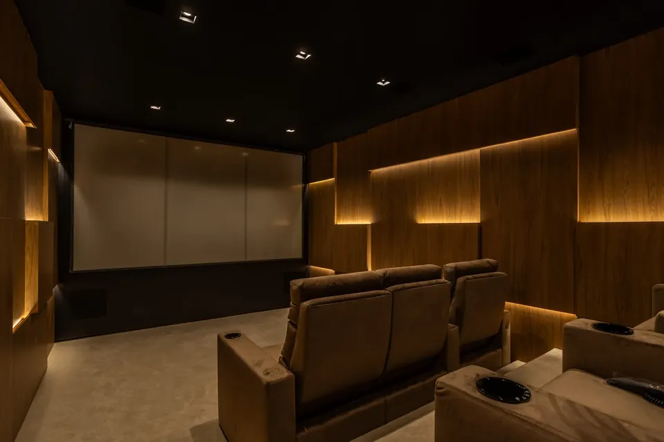 Sala de cinema com poltronas e iluminação indireta